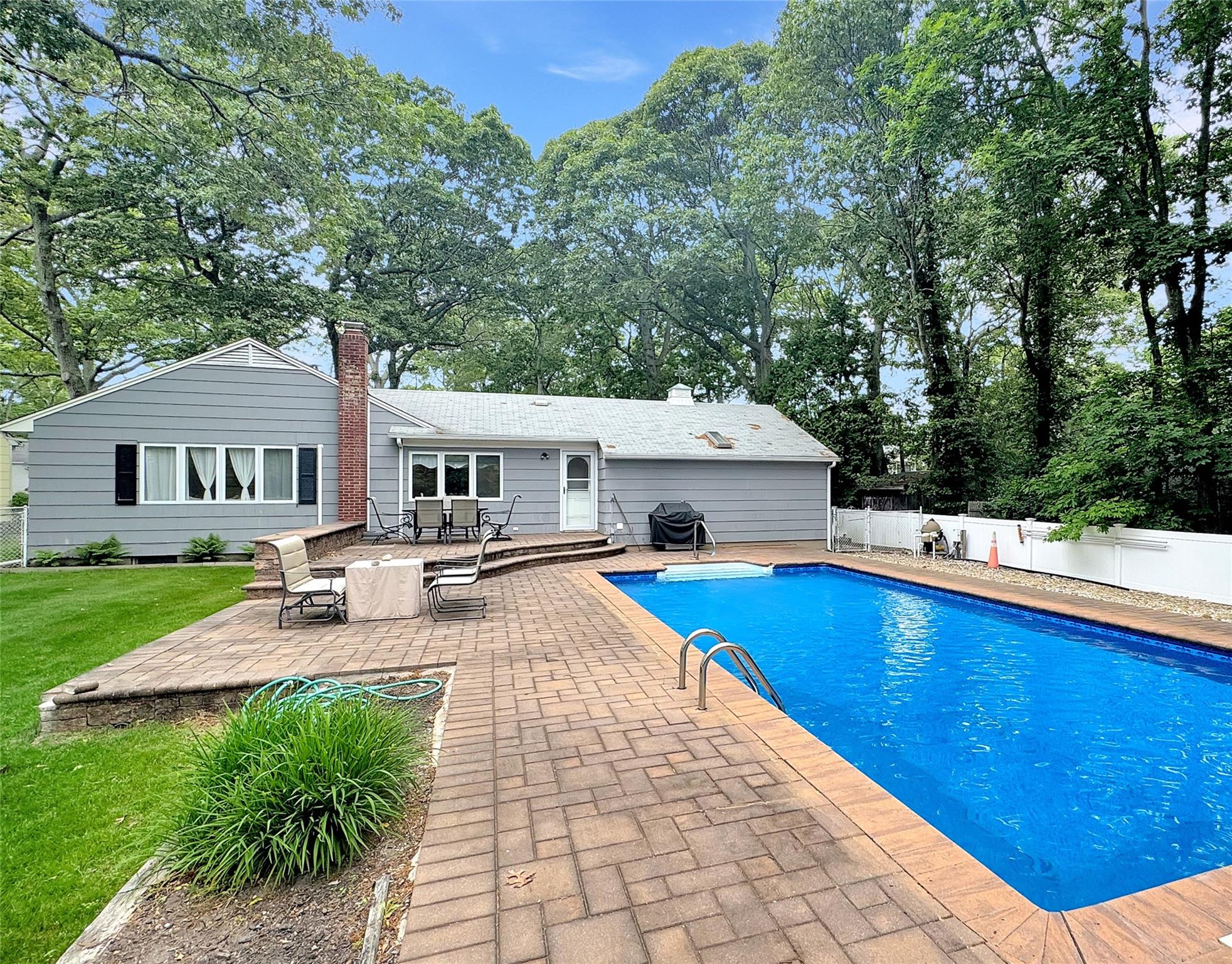 a view of a house with pool and chairs