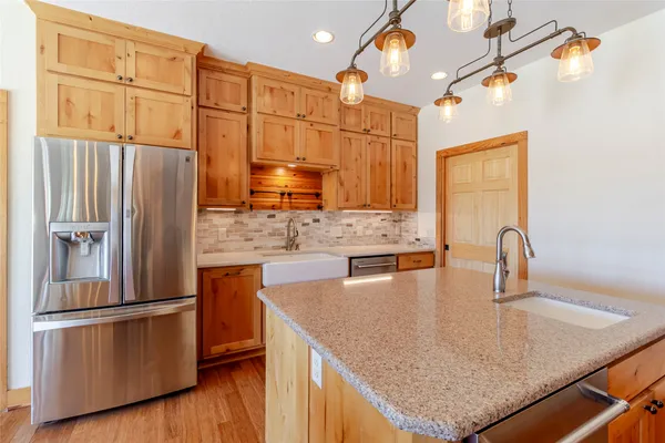 a kitchen with stainless steel appliances granite countertop a refrigerator a sink and a stove