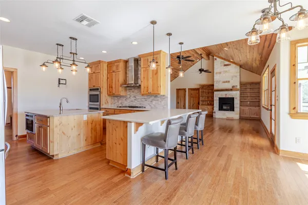 a kitchen with stainless steel appliances kitchen island wooden floors and white cabinets