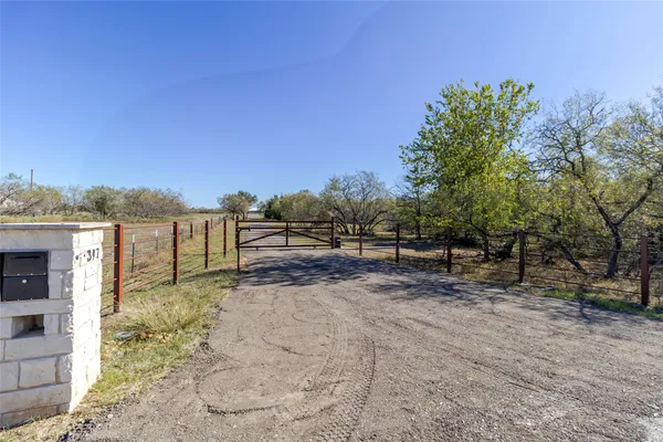 a view of a dirt road with a building in the background