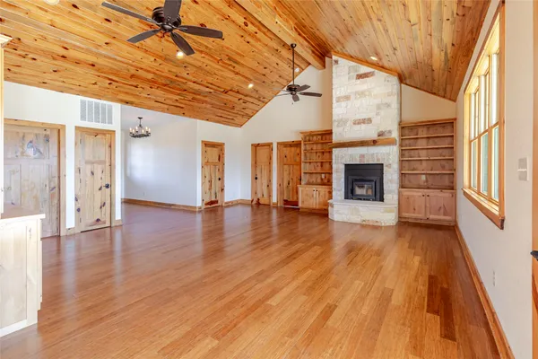 a view of empty room with wooden floor and fireplace
