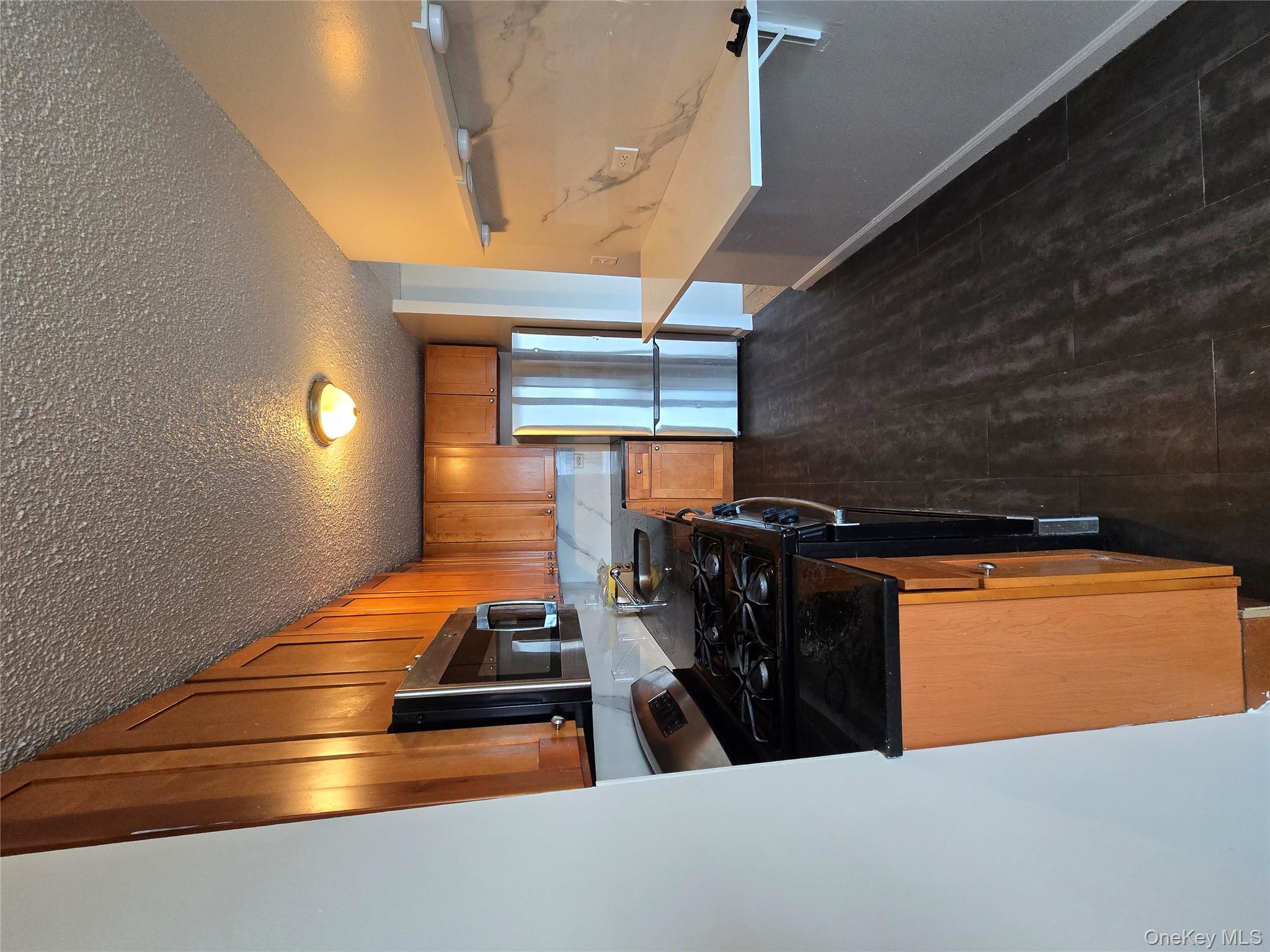 34-12 113th Street, Unit 8G Queens, NY 11368 - Photo 8 of 13 a kitchen with stainless steel appliances granite countertop a stove a sink and a refrigerator