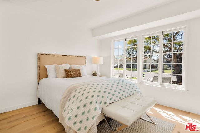 a bedroom with a bed and a large window