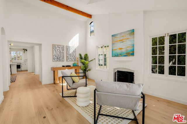 a living room with furniture a fireplace and a large window