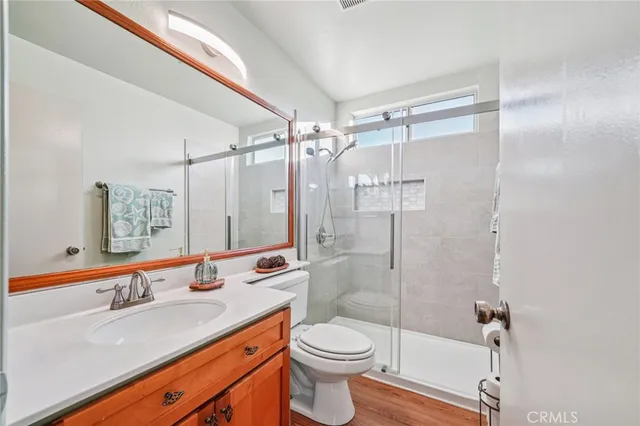 a bathroom with a double vanity sink toilet mirror and shower