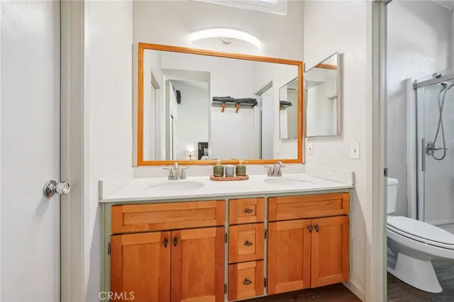 a bathroom with a granite countertop sink a toilet and a mirror