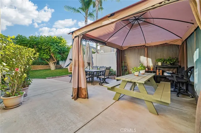 a view of the patio with dining table and chairs under an umbrella