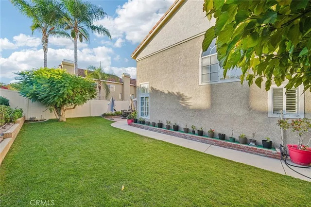 a view of a house with a yard and a palm tree