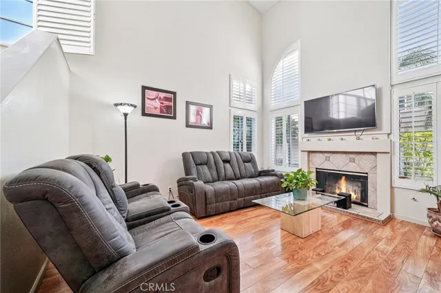 a living room with furniture a flat screen tv and a fireplace