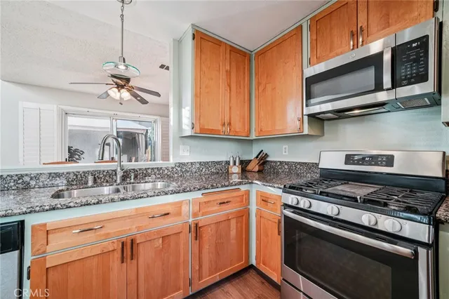 a kitchen with stainless steel appliances granite countertop a sink stove and microwave