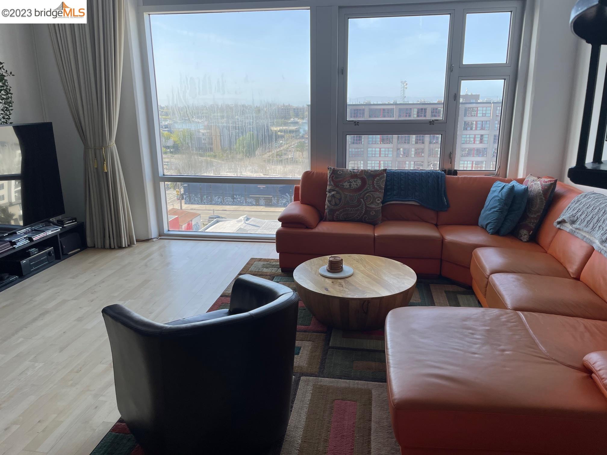 311 Oak Street, Unit PH27 Oakland, CA 94607 - Photo 4 of 21 a living room with furniture and a flat screen tv