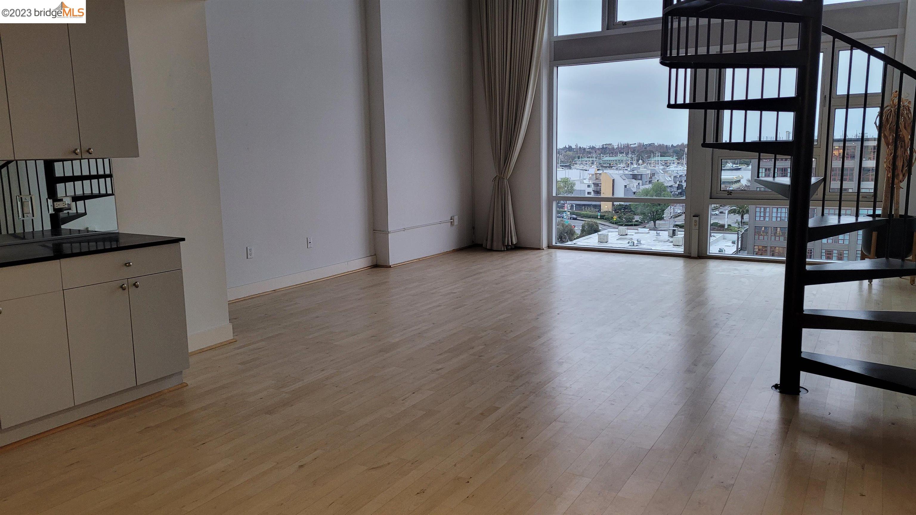 311 Oak Street, Unit PH27 Oakland, CA 94607 - Photo 8 of 21 a view of empty room with wooden floor and fan