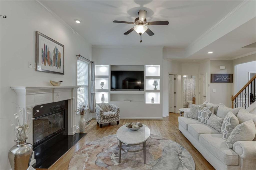 4880 Stone Moss Path Hoschton, GA 30548 - Photo 11 of 66 a living room with furniture a fireplace and a flat screen tv
