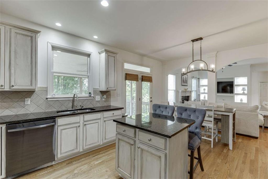 4880 Stone Moss Path Hoschton, GA 30548 - Photo 15 of 66 a kitchen with center island table and chairs in it