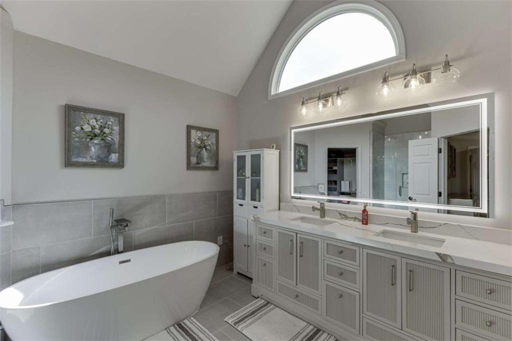 4880 Stone Moss Path Hoschton, GA 30548 - Photo 20 of 66 a spacious bathroom with a double vanity sink mirror and bathtub