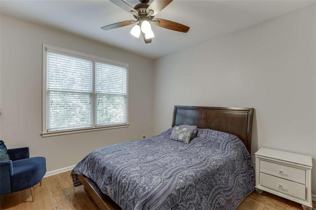 4880 Stone Moss Path Hoschton, GA 30548 - Photo 23 of 66 a bedroom with a bed and a chandelier