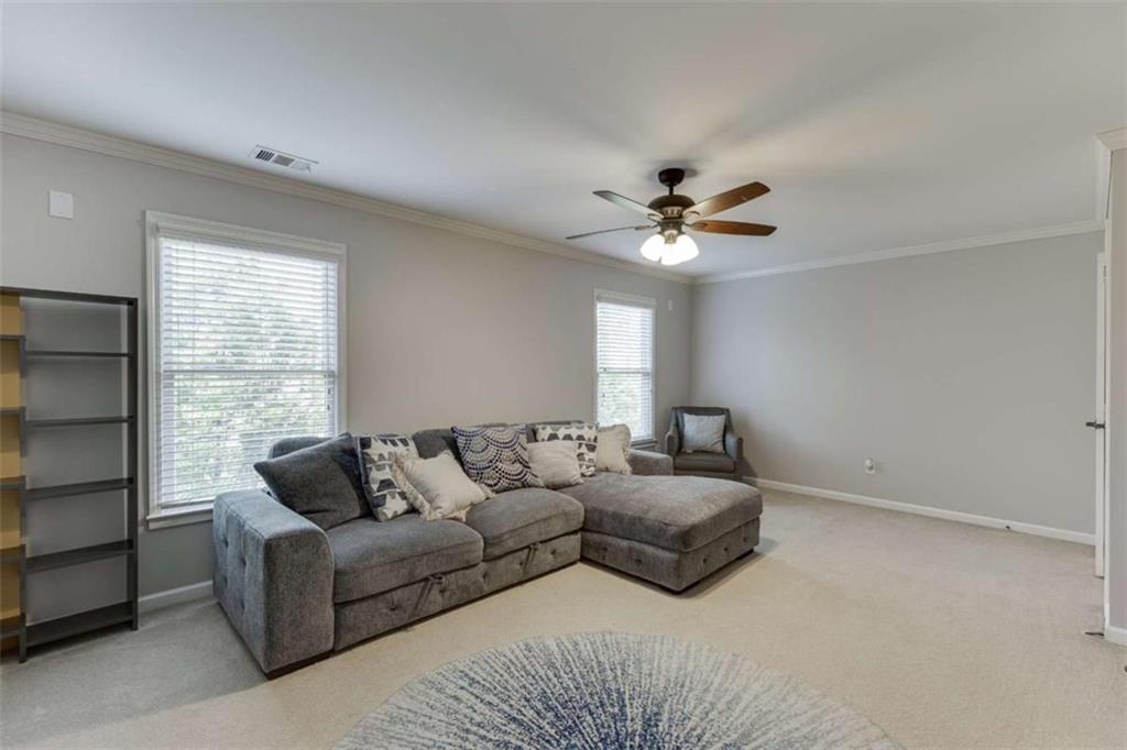 4880 Stone Moss Path Hoschton, GA 30548 - Photo 27 of 66 a living room with furniture and a large window