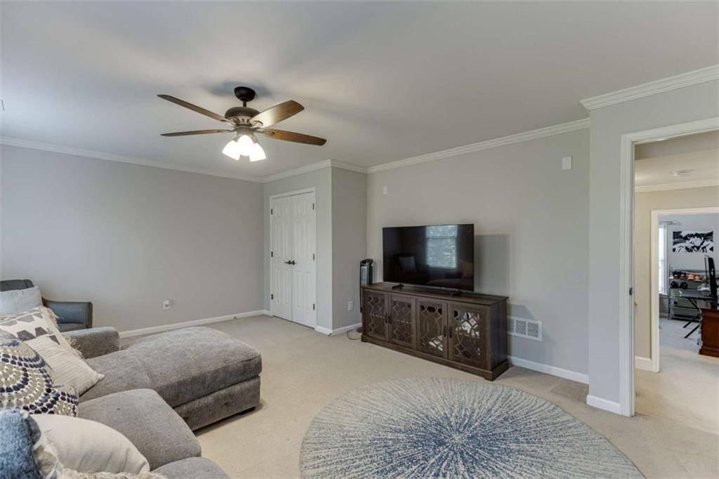 4880 Stone Moss Path Hoschton, GA 30548 - Photo 28 of 66 a living room with furniture and a flat screen tv