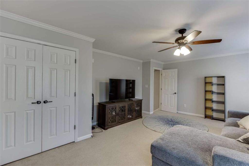 4880 Stone Moss Path Hoschton, GA 30548 - Photo 29 of 66 a living room with furniture and a flat screen tv