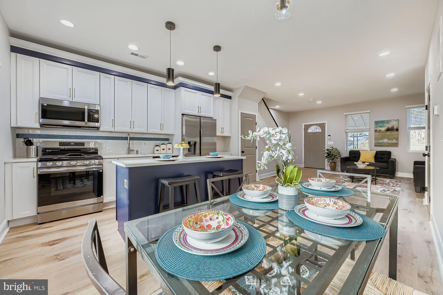 4119 Fairview Avenue Baltimore, MD 21216 - Photo 10 of 25 a open kitchen with stainless steel appliances kitchen island granite countertop a dining table and chairs with wooden floor