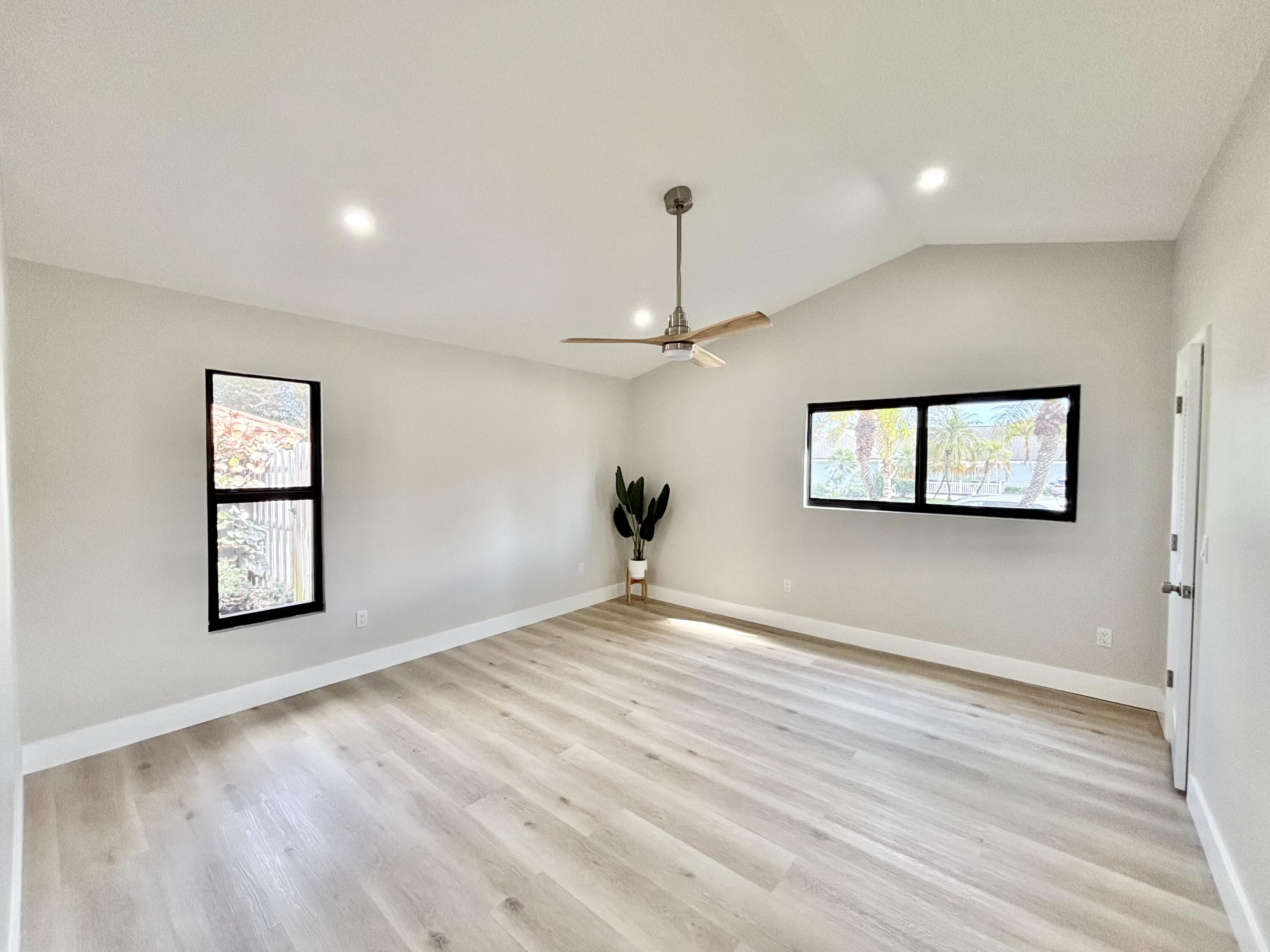 14 Southeast Paddock Circle Jupiter, FL 33469 - Photo 16 of 45 a view of an empty room with a window and wooden floor