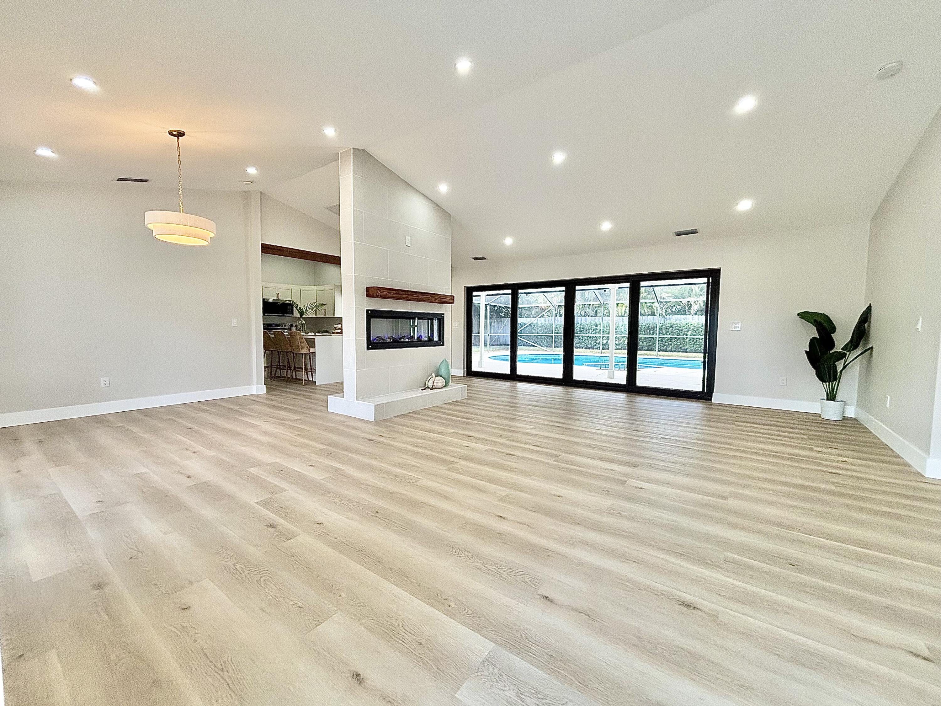 14 Southeast Paddock Circle Jupiter, FL 33469 - Photo 2 of 45 a view of an empty room with window and wooden floor