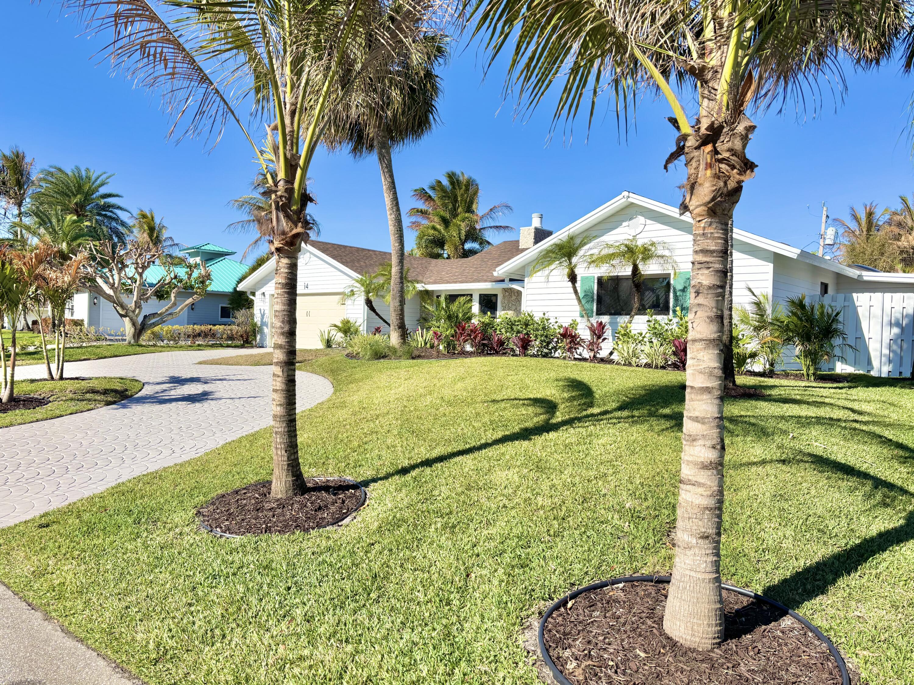 14 Southeast Paddock Circle Jupiter, FL 33469 - Photo 43 of 45 a front view of a house with fountain yard and palm tree