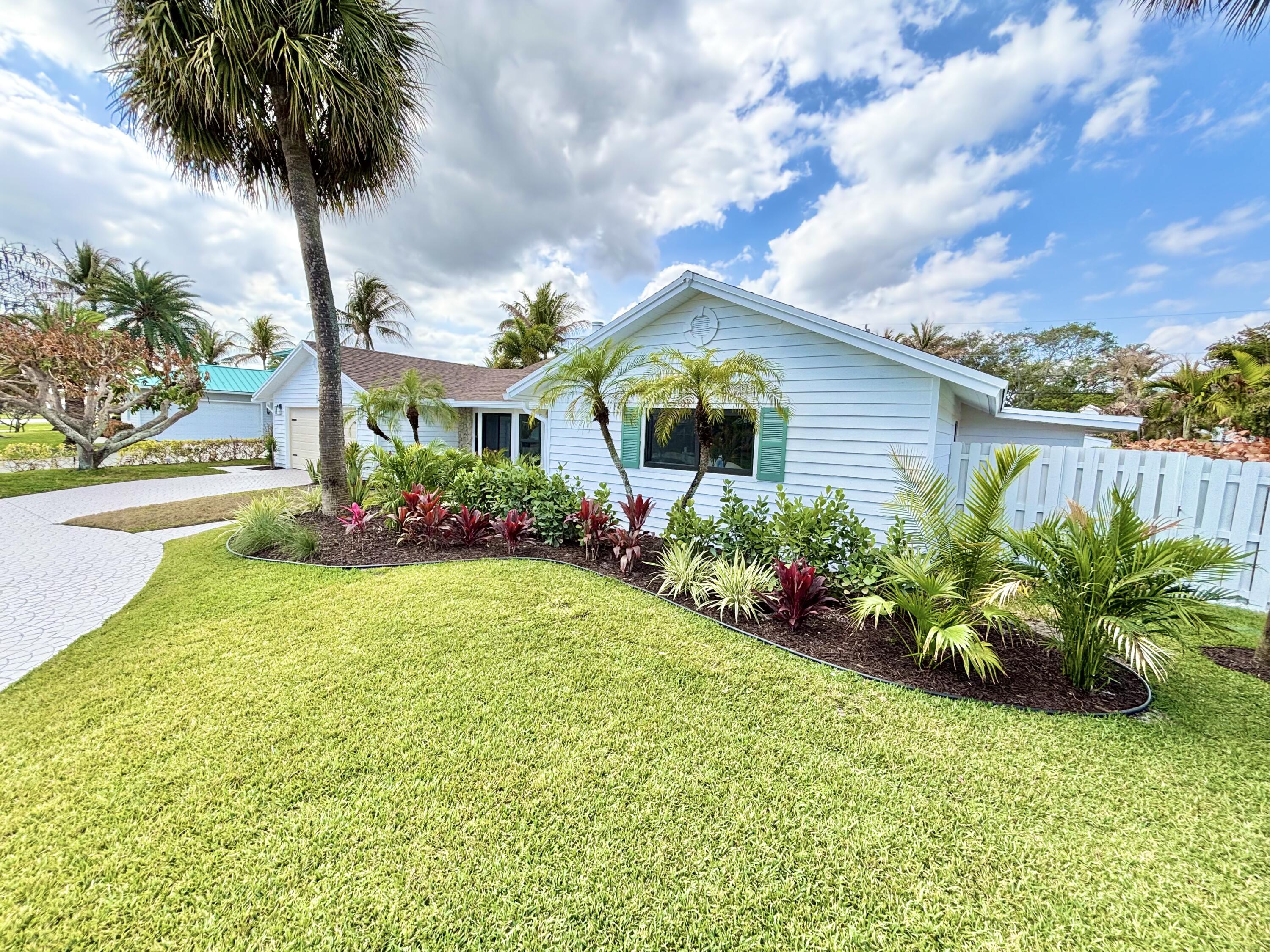 14 Southeast Paddock Circle Jupiter, FL 33469 - Photo 44 of 45 a front view of a house with garden