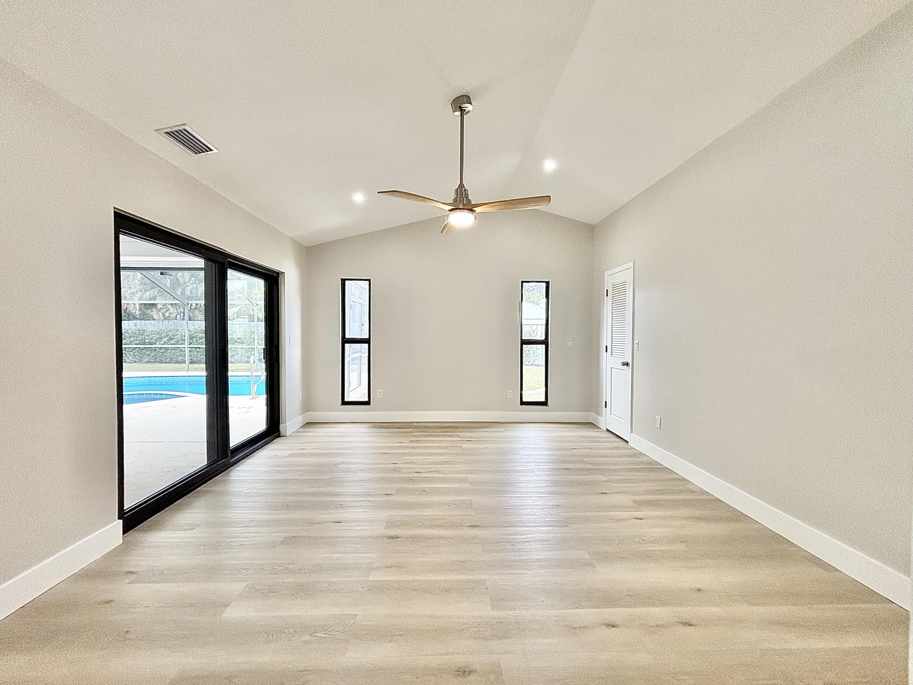 14 Southeast Paddock Circle Jupiter, FL 33469 - Photo 7 of 45 a view of an empty room with window and wooden floor