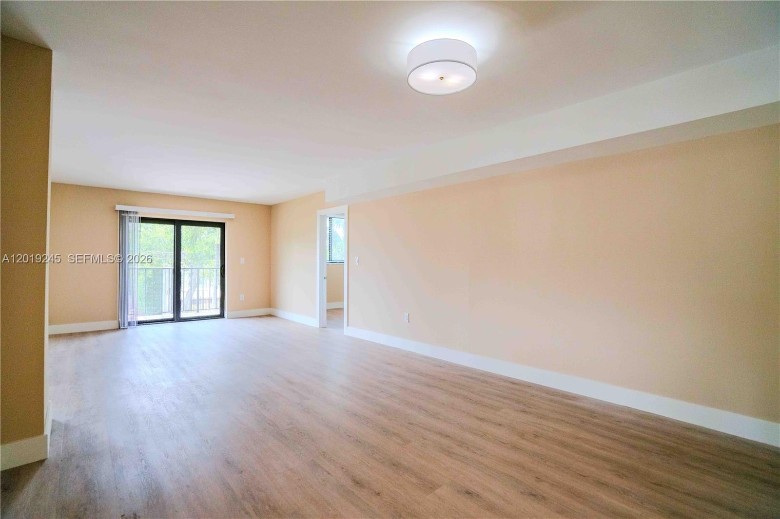 6960 Rue Vendome, Unit 201 Miami Beach, FL 33141 - Photo 4 of 27 a view of an empty room with wooden floor and a window