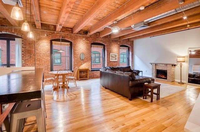 a living room with furniture a fireplace and wooden floor