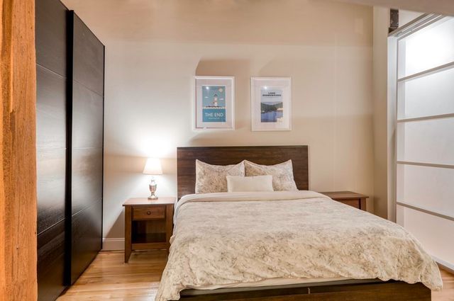 a bedroom with a bed and wooden floor