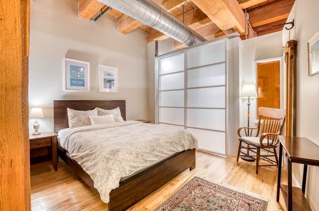a large bed sitting in a bedroom next to a window