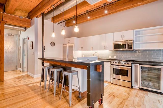a kitchen with stainless steel appliances granite countertop a stove a sink and a refrigerator