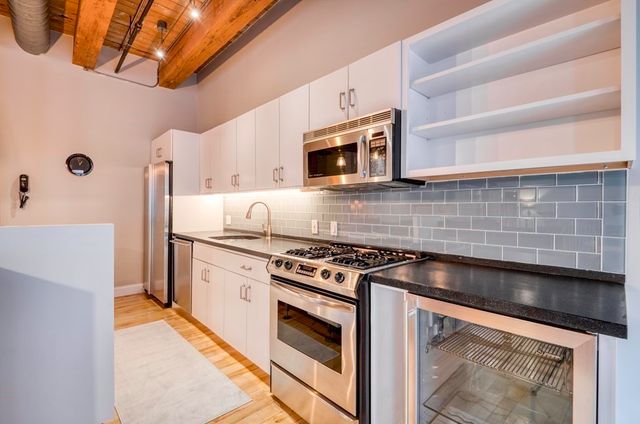 a kitchen with stainless steel appliances granite countertop a stove and a microwave