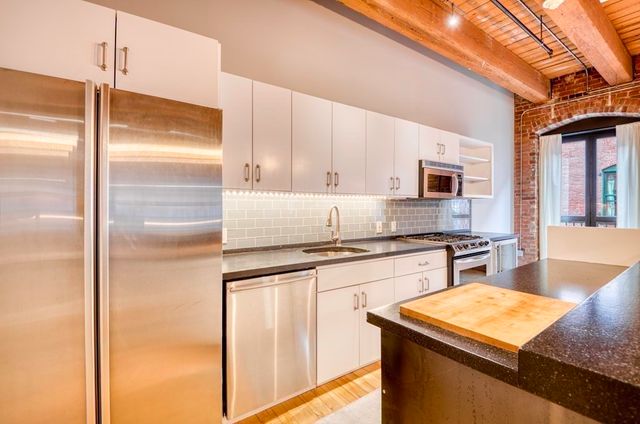 a kitchen with stainless steel appliances granite countertop a sink stove and refrigerator