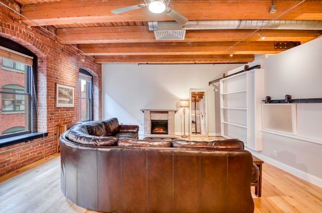 a living room with fireplace furniture and a floor to ceiling window