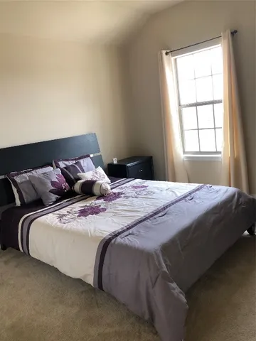 a bedroom with a bed and window