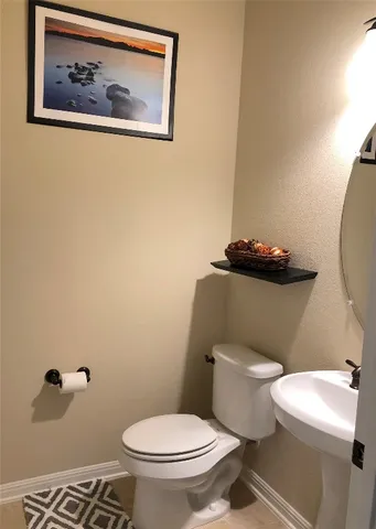 a white toilet sitting next to a bathroom sink and a mirror
