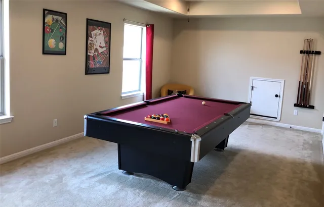 a room with pool table and paintings on the wall