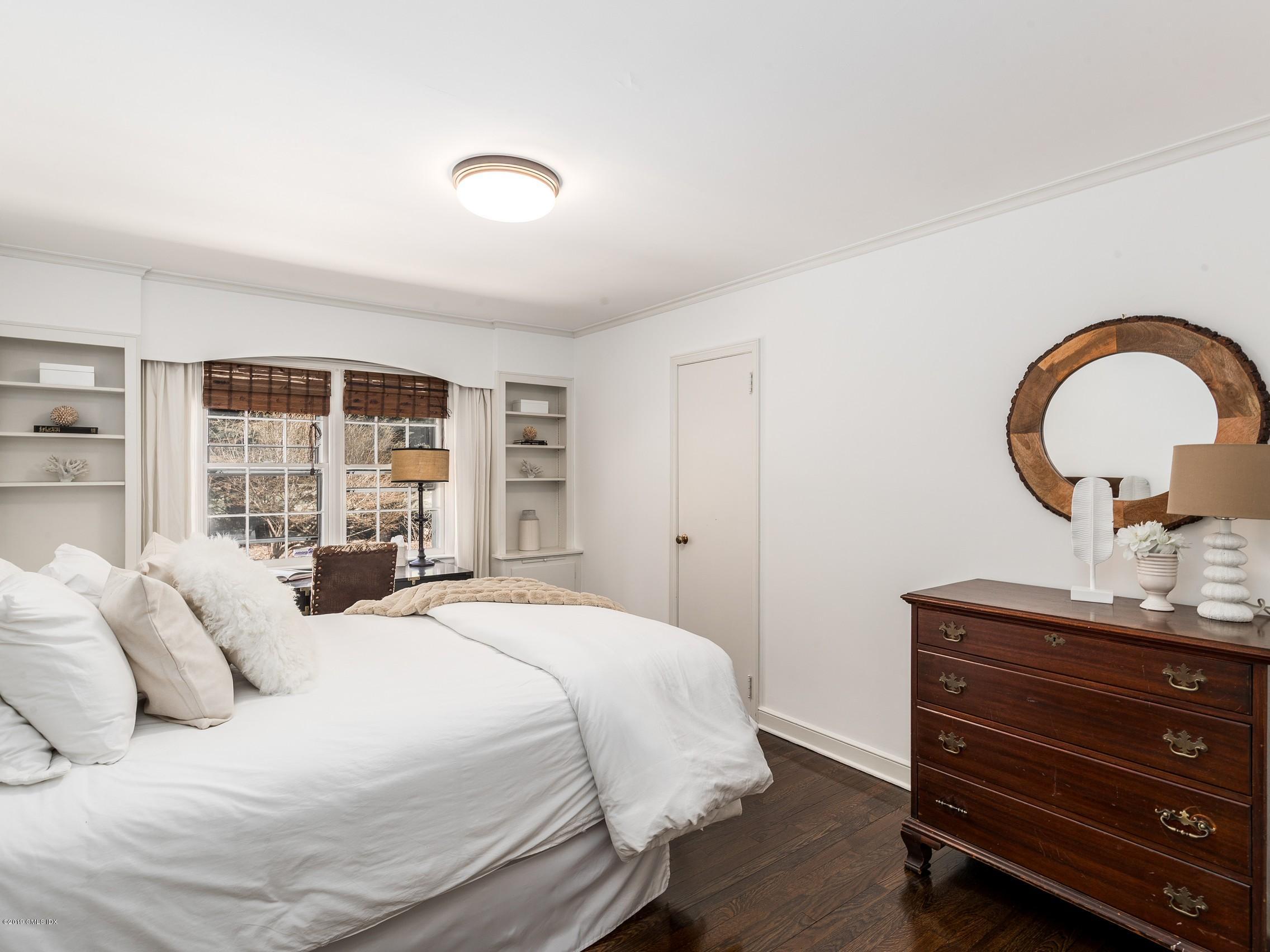 66 Bruce Park Drive Greenwich, CT 06830 - Photo 13 of 27 a bedroom with a bed and a large window