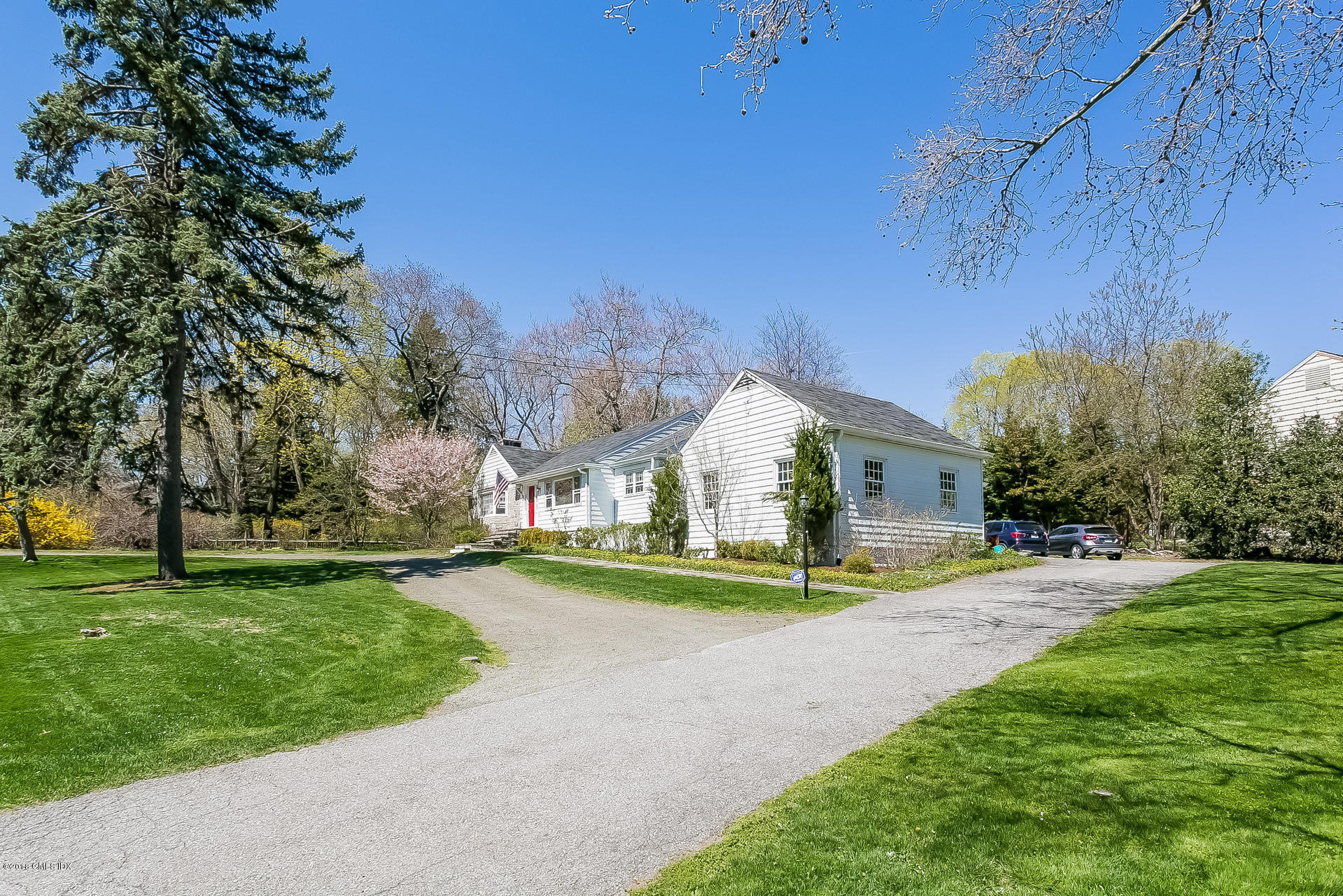 66 Bruce Park Drive Greenwich, CT 06830 - Photo 19 of 27 a view of a house with a big yard and large trees