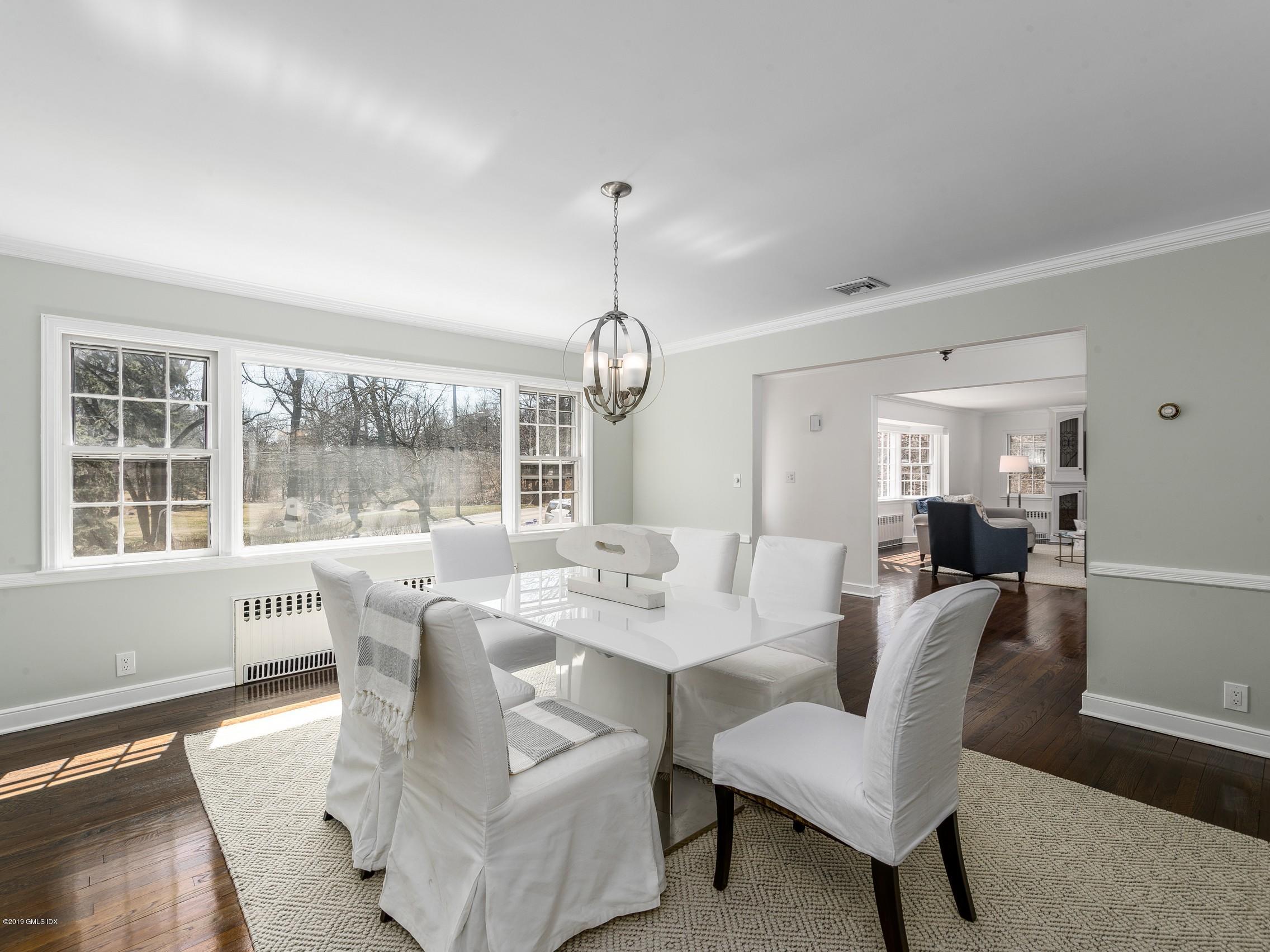 66 Bruce Park Drive Greenwich, CT 06830 - Photo 6 of 27 a dining room with furniture a chandelier and wooden floor