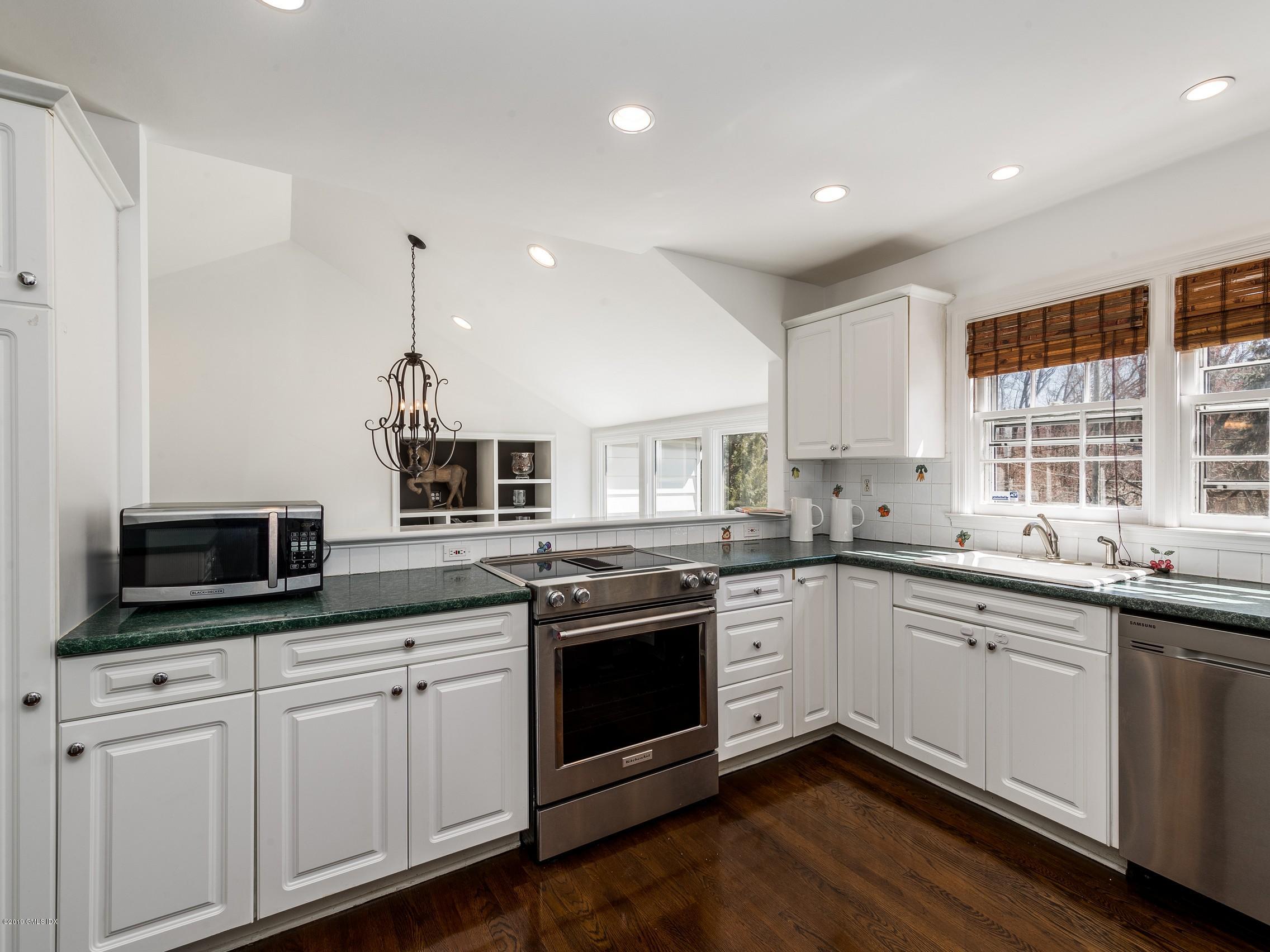 66 Bruce Park Drive Greenwich, CT 06830 - Photo 9 of 27 a kitchen with stainless steel appliances granite countertop a sink and stove top oven