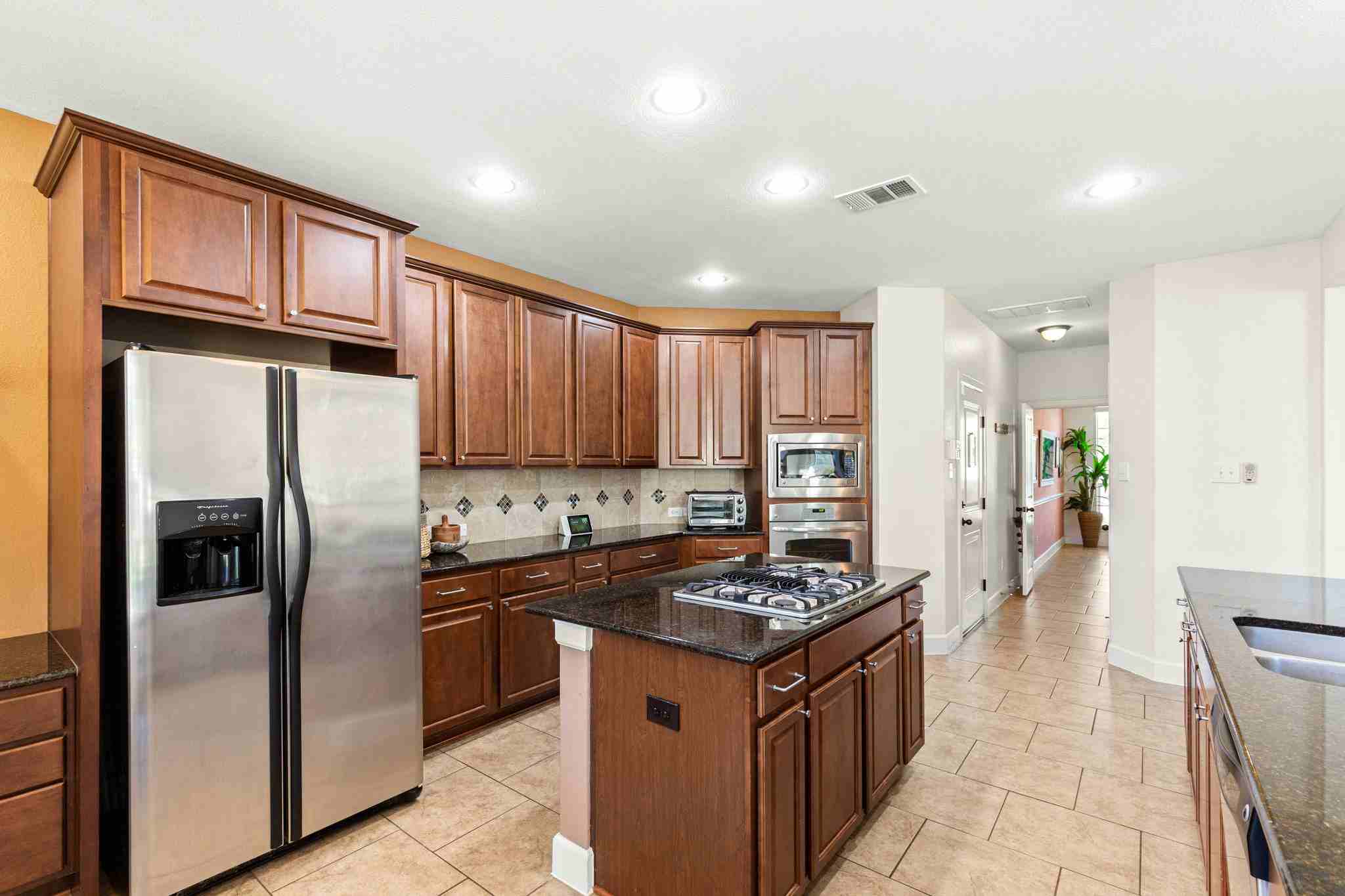2525 Quick Fort Drive Leander, TX 78641 - Photo 13 of 39 a kitchen with stainless steel appliances granite countertop a stove refrigerator sink and cabinets