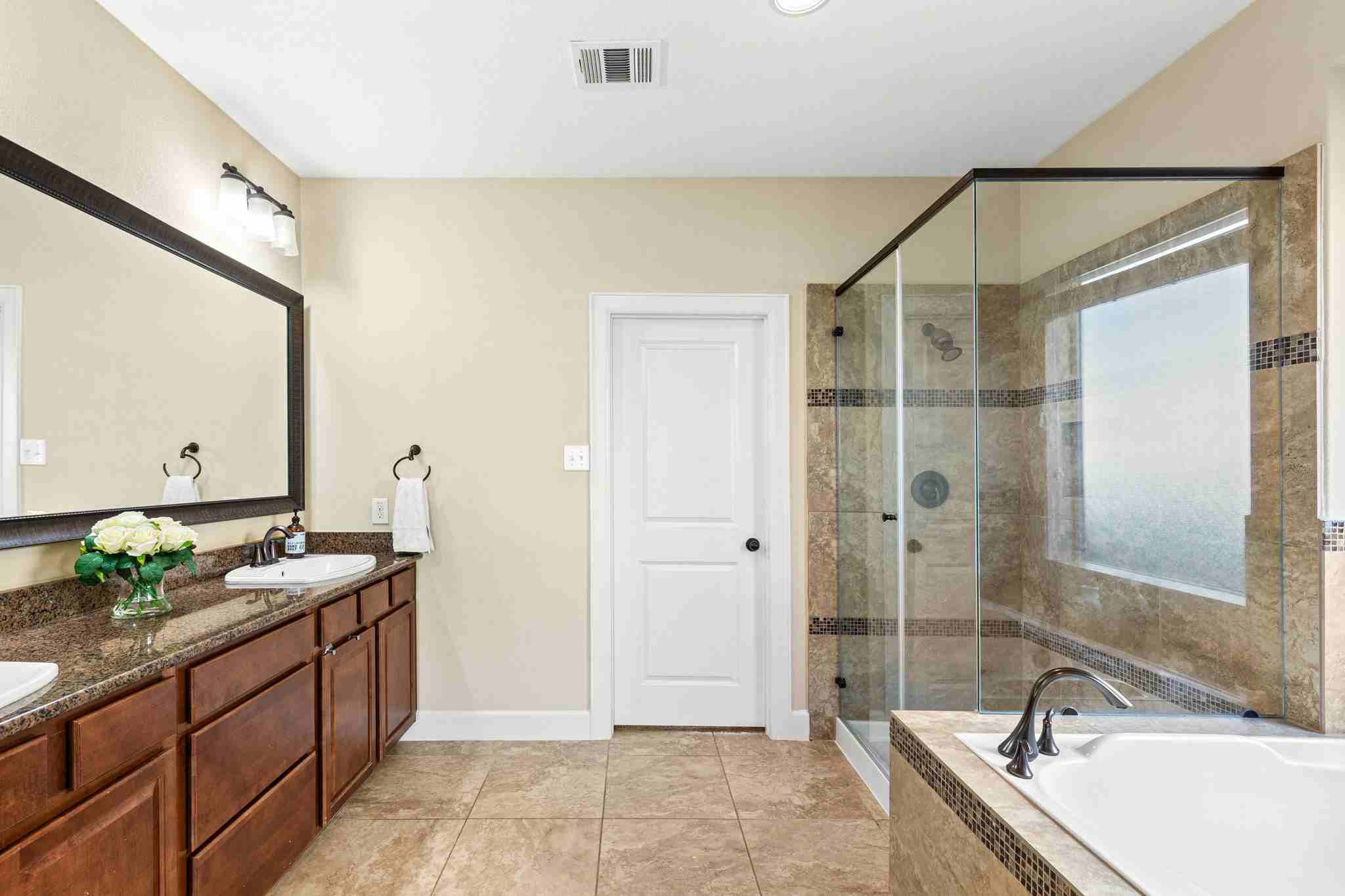 2525 Quick Fort Drive Leander, TX 78641 - Photo 19 of 39 a spacious bathroom with a granite countertop tub sink and mirror