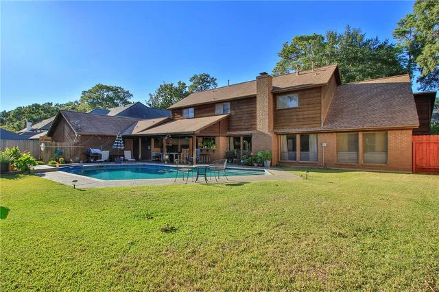 a view of an house with swimming pool and chairs