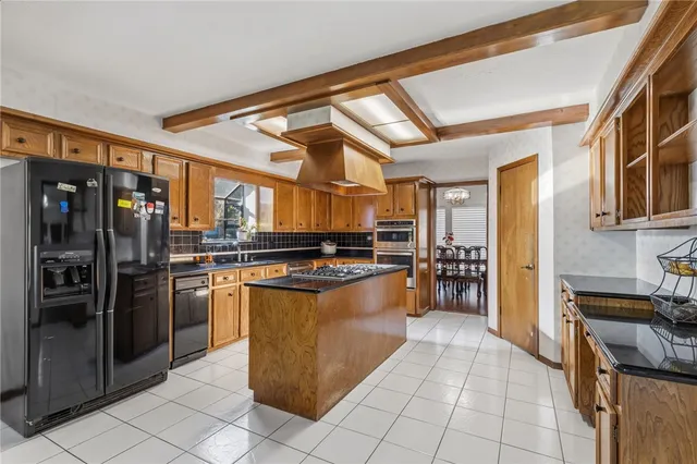 a kitchen with stainless steel appliances granite countertop a refrigerator and a stove top oven
