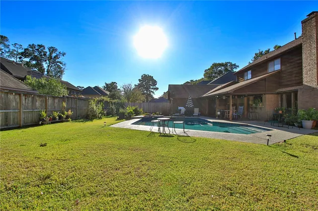 a view of a house with swimming pool and a yard