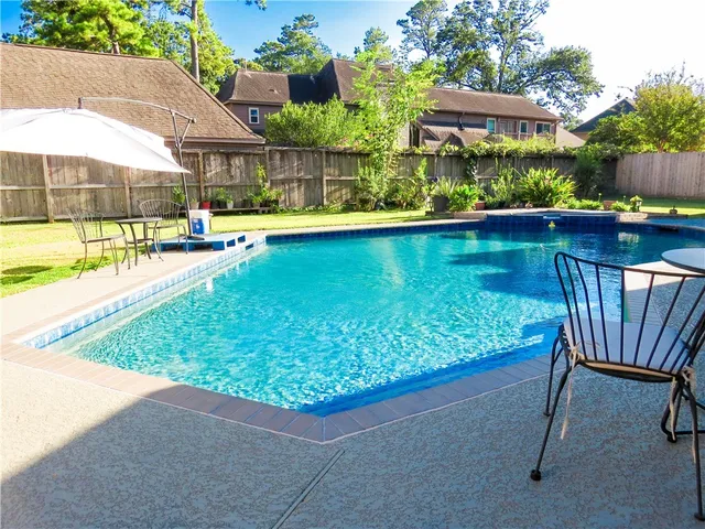 a view of swimming pool with outdoor seating and a garden